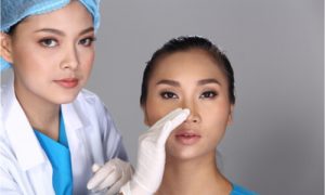 A surgeon attending to her patient for a nose job.